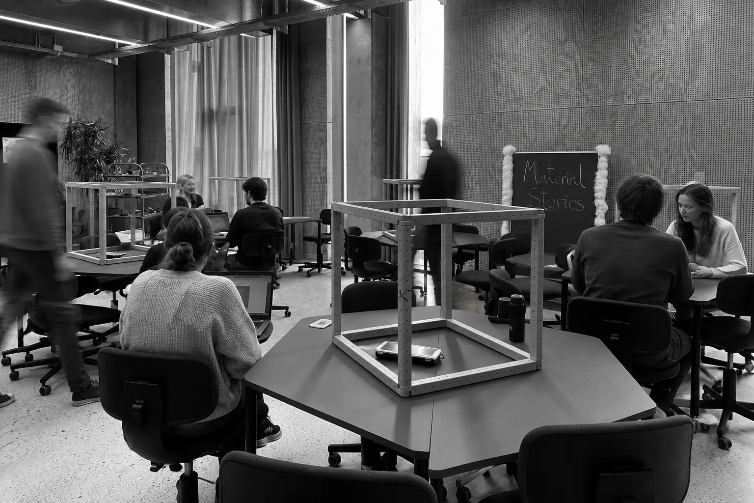 Deltagere ved en Loom Learning-workshop samlet omkring et bord med materialer til fælles undersøgelse
